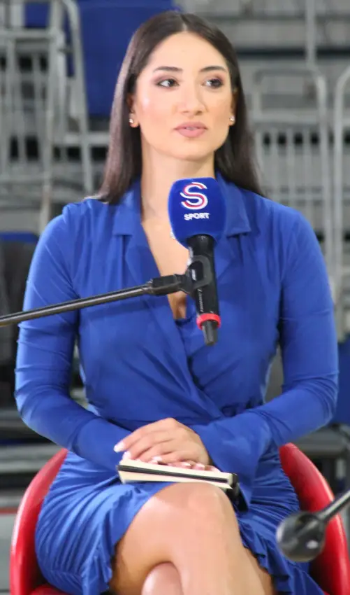 Deniz Aksoy seated courtside with an S Sport microphone