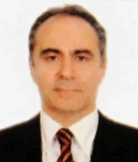 Mehmet Bilen in a dark suit and striped tie