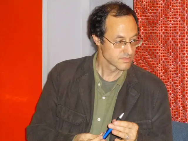 Tanıl Bora seated alone at a public event